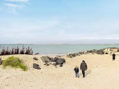 a man and a child walking on a beach at 5 person holiday home in Thyborøn in Thyborøn