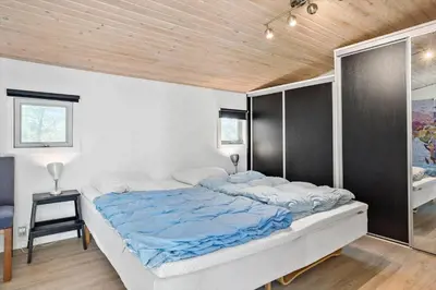 a large bed in a bedroom with a wooden ceiling at LF14198-Roslev-Bagvejen-2 in Roslev