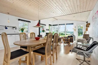 a kitchen and dining room with a wooden table and chairs at LF14198-Roslev-Bagvejen-2 in Roslev