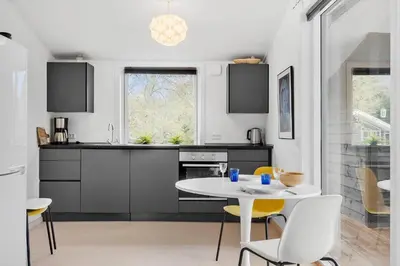 a kitchen with a white table and yellow chairs at LF10320-Hurup-Thy-Nattergalevej-2-B in Sønder Ydby