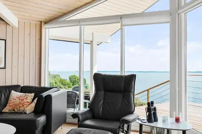 a screened in porch with chairs and a table at LF14194-Roslev-Bagvejen-26 in Roslev