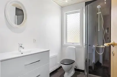 a white bathroom with a toilet and a shower at LF10236-Thyholm-Svinget-18 in Thyholm