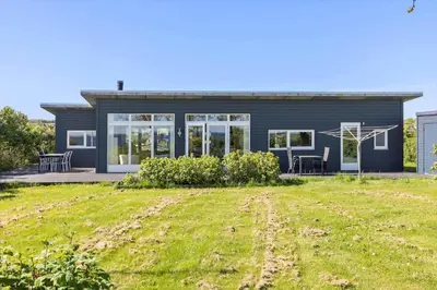 a blue house with a lawn in front of it at LF14038-Roslev-Stranddalen-119 in Roslev
