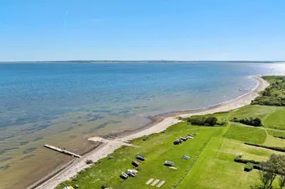an aerial view of a field next to the ocean at LF14038-Roslev-Stranddalen-119 in Roslev