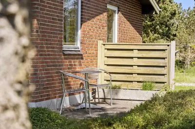 a chair sitting next to a building with a window at LF10314-Hurup-Thy-Edderfuglevej-15 in Sindrup