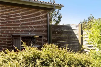 a red brick building with a wooden fence at LF10314-Hurup-Thy-Edderfuglevej-15 in Sindrup