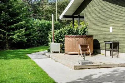 a patio with a table and a chair next to a house at LF14163-Roslev-Kybehuse-3 in Roslev