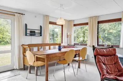 a dining room with a wooden table and chairs at LF10213-Thyholm-Haervej-9-B in Thyholm