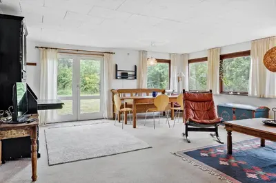 a living room with a table and chairs at LF10213-Thyholm-Haervej-9-B in Thyholm