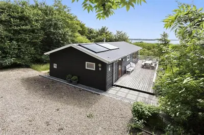 a black tiny house with a wooden deck at LF483-Snedsted-Bjergvej-8 in Snedsted