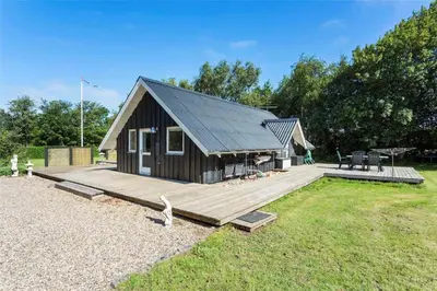 a small cabin with a large wooden deck at LF12017-Spottrup-Albaekparken-144 in Spottrup