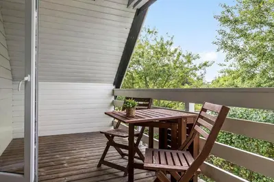 a wooden table and two chairs on a deck at LF14127-Roslev-Kybehuse-127 in Roslev