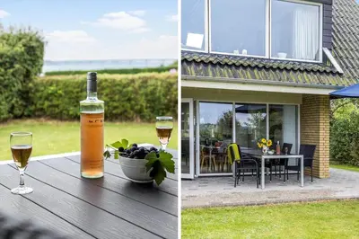 a bottle of wine and a glass on a wooden table at LF14127-Roslev-Kybehuse-127 in Roslev