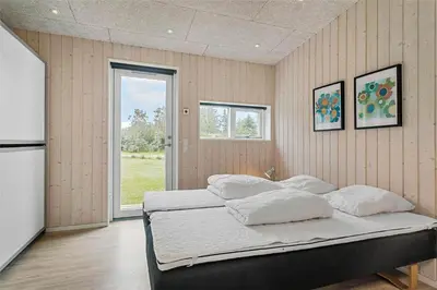 a bedroom with a large bed with white pillows at LF14137-Spottrup-Fjordvej-39 in Spottrup
