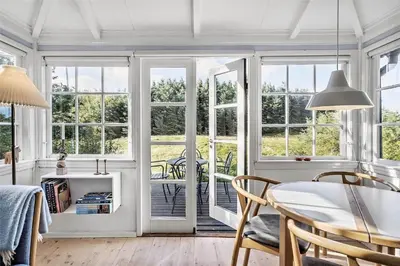 a living room with a table and chairs and windows at LF11974-Struer-Havstokken-15A in Struer
