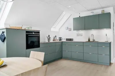 a kitchen with blue cabinets and a table in it at LF11122-Struer-Plantagevej-22 in Struer