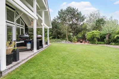 a backyard with a grill on the side of a house at LF10058-Thyholm-Fyrrevej-17 in Thyholm