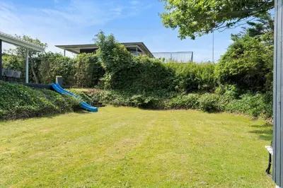 a backyard with a blue slide in the grass at LF11107-Struer-Skovvej-7 in Struer