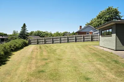 a large yard with a fence and a house at LF11597-Struer-Plantagevej-97 in Struer