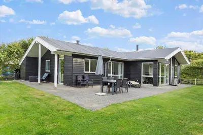 a house with a table and chairs in a yard at LF338-Vestervig-Gunhildsvej-38 in Vestervig