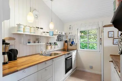 a kitchen with white cabinets and a sink and a window at LF10221-Thyholm-Haervej-21 in Thyholm