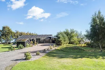 a house with a gambrel roof and a driveway at LF10210-Thyholm-Skovstien-10 in Thyholm