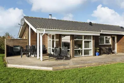a house with a wooden deck with chairs at LF884-Snedsted-Kongens-Borer-2 in Snedsted