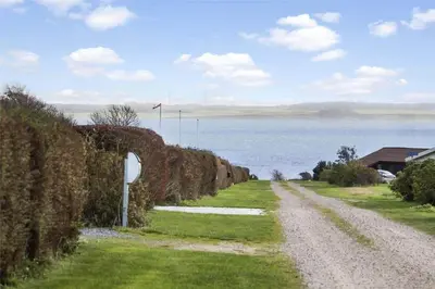 a dirt road next to a large body of water at LF884-Snedsted-Kongens-Borer-2 in Snedsted