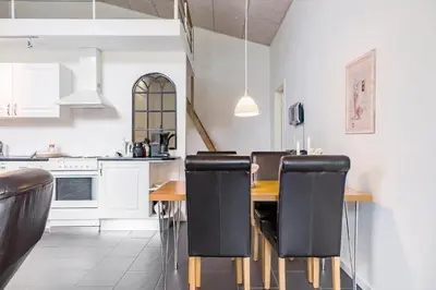 a kitchen with a wooden table and black chairs at LF14211-Roslev-Vile-Vestergardvej-34-Lejl-A-tv in Roslev