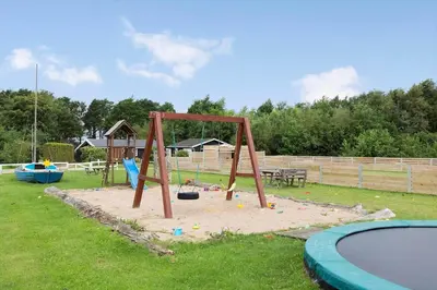 a child playing on a swing set in a park at LF14211-Roslev-Vile-Vestergardvej-34-Lejl-A-tv in Roslev
