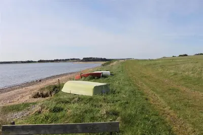 a grassy field next to a body of water at LF14211-Roslev-Vile-Vestergardvej-34-Lejl-A-tv in Roslev