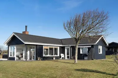 a black house with a tree in the yard at LF888-Snedsted-Over-Reese-5 in Snedsted