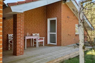 a patio with a table and chairs on a wooden deck at LF10229-Thyholm-Skovstjernevej-9 in Thyholm