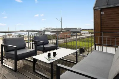 a balcony with two chairs and a table and a view at LF10214-Thyholm-Havnefronten-14 in Thyholm