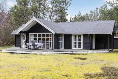 a black house with a porch and a patio at LF10307-Hurup-Thy-Traelobervej-7 in Sønder Ydby