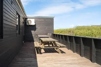 a wooden deck with a picnic table on the side of a house at LF12086-Vinderup-Vigen-86 in Vinderup