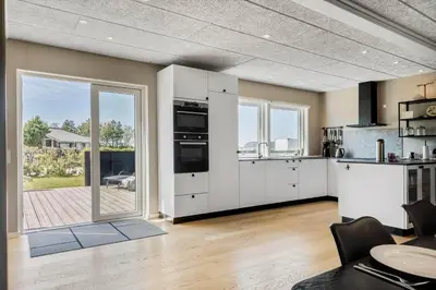 a kitchen with white cabinets and a large sliding glass door at LF12086-Vinderup-Vigen-86 in Vinderup