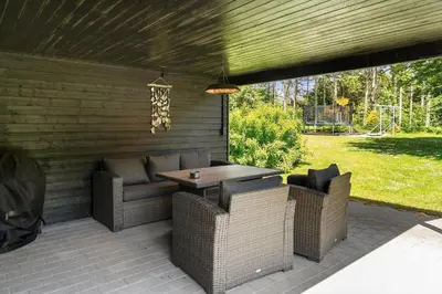 a patio with a table and wicker chairs at LF10302-Hurup-Thy-Skibstedsvej-22-B in Sønder Ydby