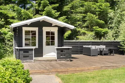a black shed with a table and chairs on a wooden deck at LF10302-Hurup-Thy-Skibstedsvej-22-B in Sønder Ydby