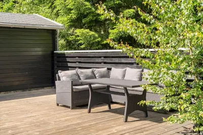 a patio with a table and a bench on a deck at LF10302-Hurup-Thy-Skibstedsvej-22-B in Sønder Ydby