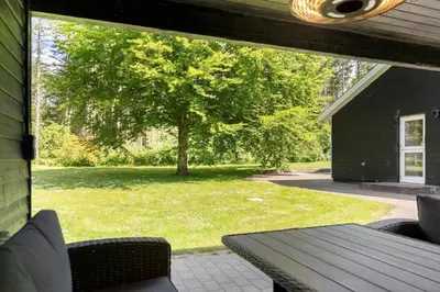 a screened porch with a table and a tree at LF10302-Hurup-Thy-Skibstedsvej-22-B in Sønder Ydby