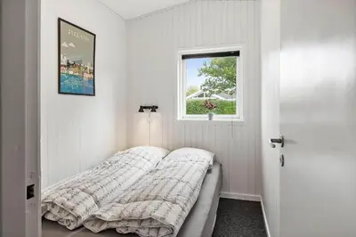 a white bedroom with a bed and a window at LF11103-Struer-Blabaervej-3 in Struer