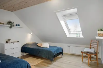 a attic bedroom with a bed and a window at LF10301-Hurup-Thy-Sindrupvej-1-B in Sindrup