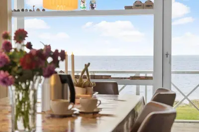 a dining room table with a view of the ocean at LF12183-Vinderup-Avej-28 in Vinderup