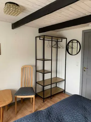a bedroom with a book shelf and a chair at Købmandsgården i Blære in Års