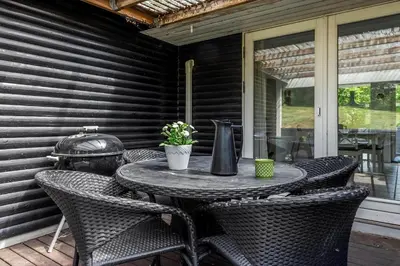 a table and chairs on a porch with a table and chairs at LF0027-Thyholm-Sondbjerg-Strandvej-27 in Thyholm