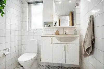 a white bathroom with a toilet and a sink at LF0027-Thyholm-Sondbjerg-Strandvej-27 in Thyholm