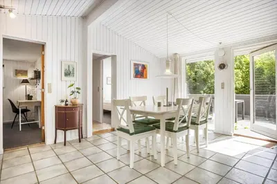 a dining room with a table and chairs at LF0027-Thyholm-Sondbjerg-Strandvej-27 in Thyholm