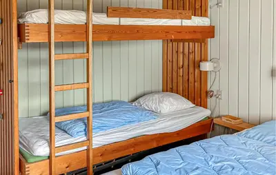 a bunk bed with a ladder next to a bed at Beautiful Home In Pandrup With Wifi in Pandrup