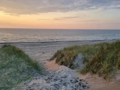 a sandy beach with the ocean in the background at 6 person holiday home in Thisted in Thisted